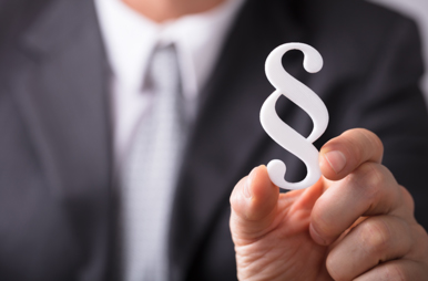 Businessman in a suit holds paragraph-sign